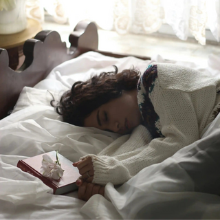 Girl sleeping with a book - welb organics sleep tea