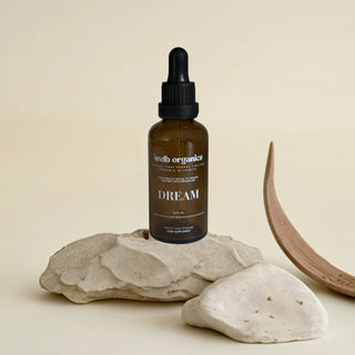 Bottle of 'Dream' on a stone surface with a neutral background