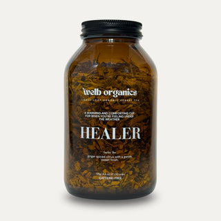Brown bottle labeled 'Healer' by welb organics on a neutral background
