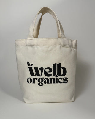 Beige tote bag with 'welb organics' text on a gray background