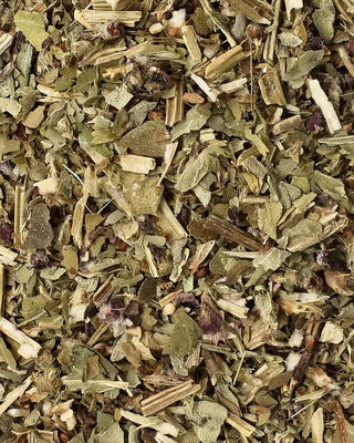 Close-up of dried tulsi herbs and leaves with a mix of green and brown colors.